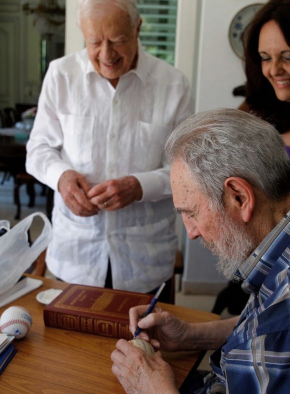 Fidel Castro (derecha) firmas una pelota de béisbol para el ex presidente de EE.UU. Jimmy Carter durante una reunión en La Habana. (Alex Castro / AFP / Getty Images)